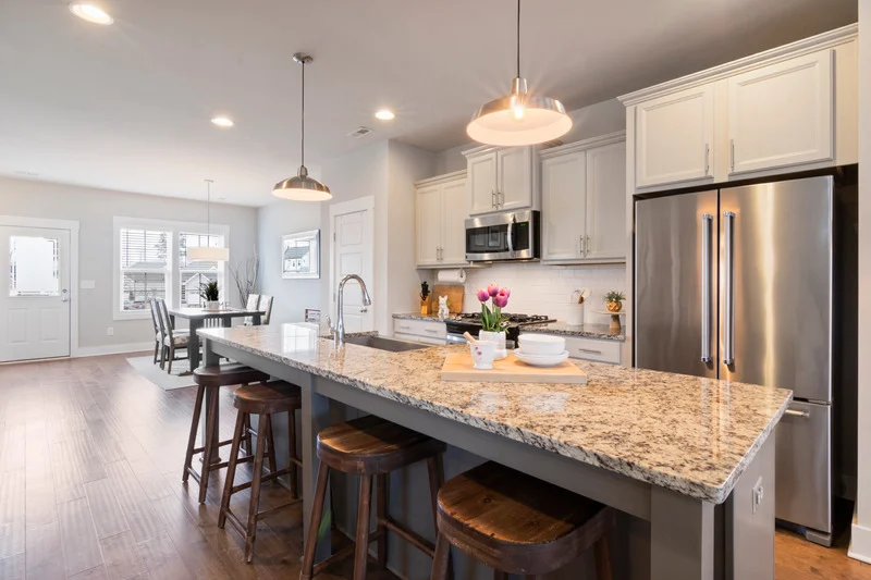 Bright, freshly cleaned modern kitchen with granite countertops and stainless steel appliances