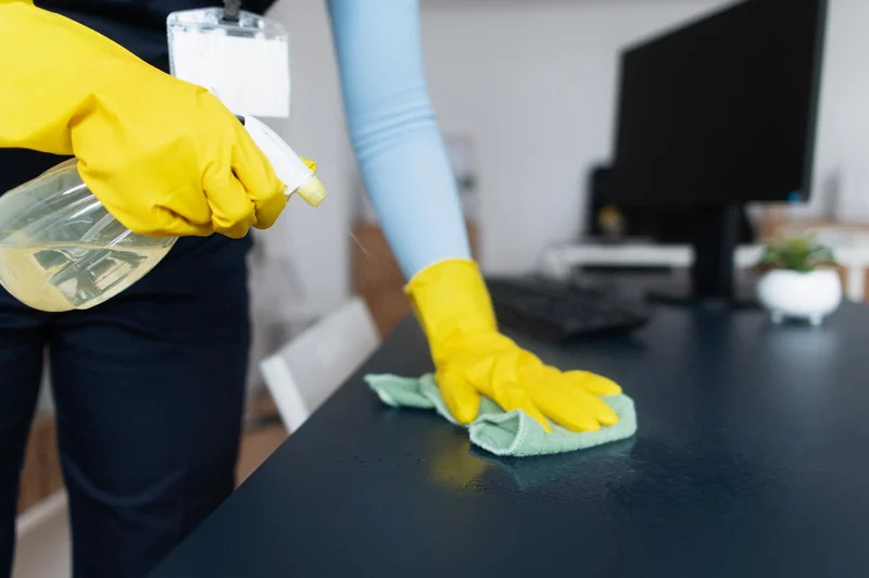 Cleaning professional wiping down a desk