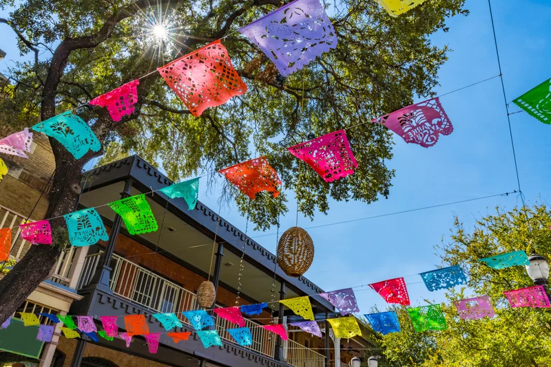 Colorful papel picado banners strung along a San Antonio street